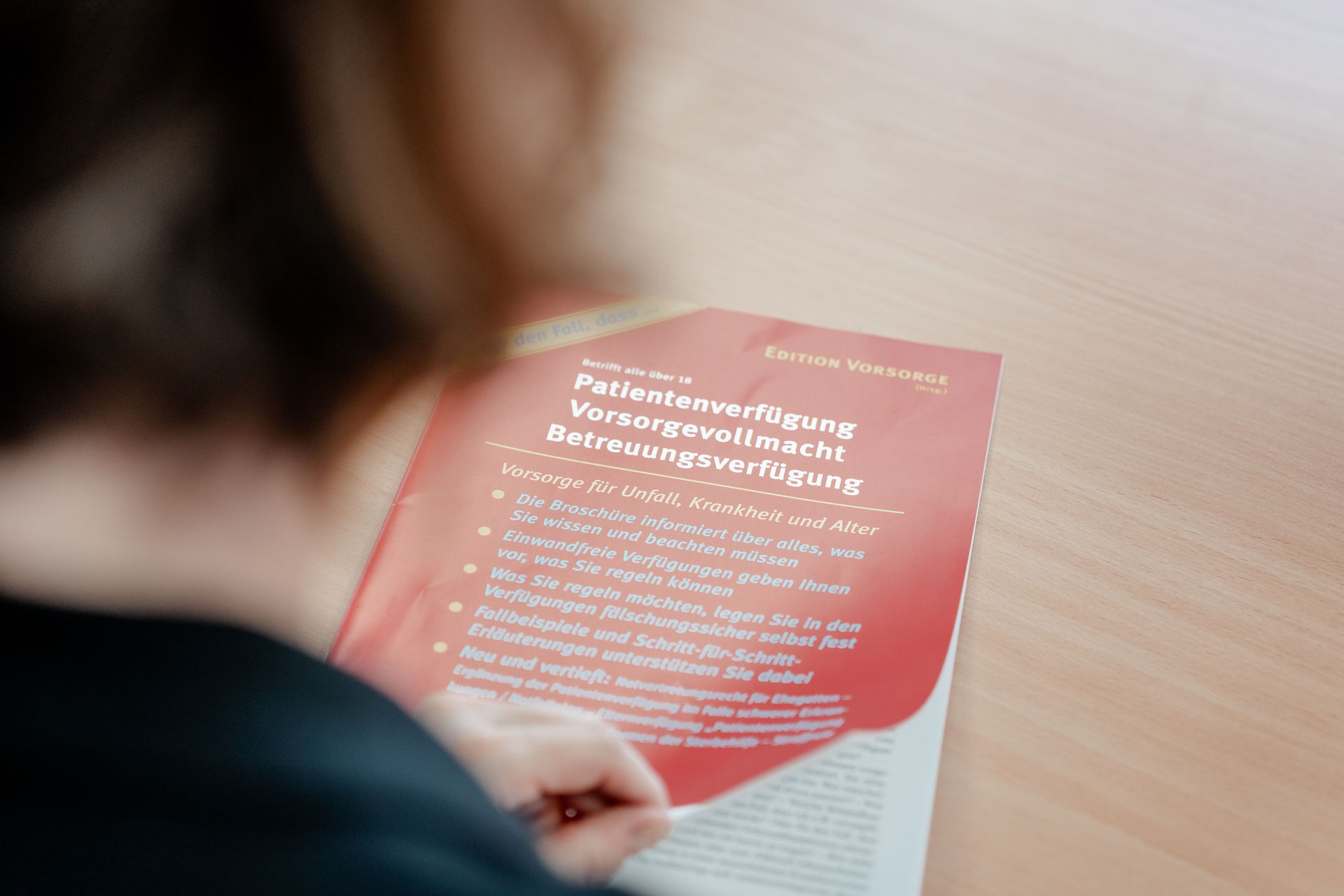 Gesetzliche Betreuung und Vorsorgevollmacht Blick über die Schulter einer Frau auf eine Infobroschüre zum Thema Gesetzliche Betreuung und Vorsorgevollmacht